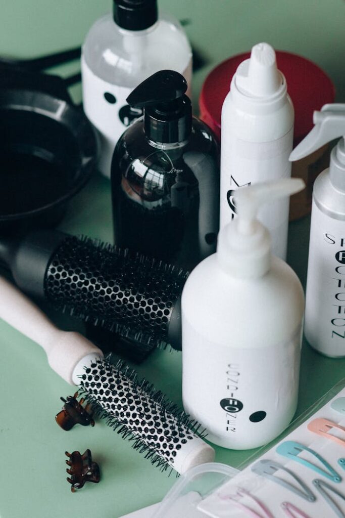 pexels-photo-8467960 Close-up of hairstyling tools and cosmetic bottles on a green background for salon use.